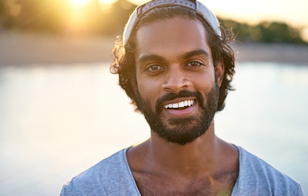 a person smiling and walking on a beach