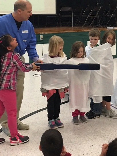 Dentist showing kids how to brush teeth