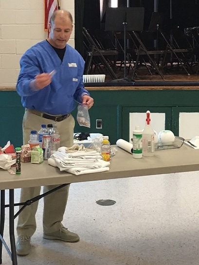 Dentist putting objects in plastic bag at community event