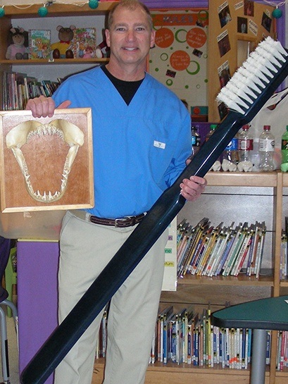 Dentist holding an oversized toothbrush