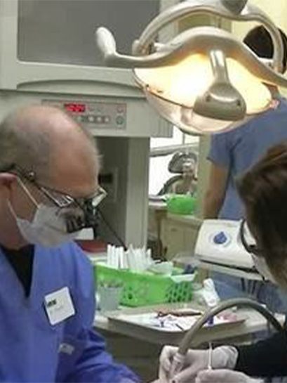 Dentist and team member treating dental patient