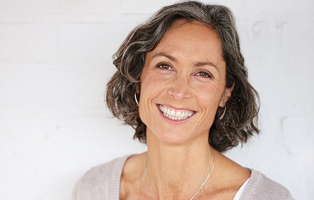 Woman with dark gray hair grinning