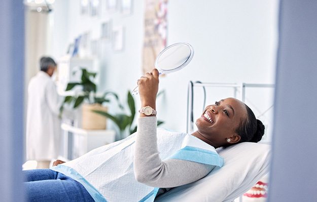 Woman smiling while looking at reflection in mirror