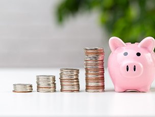 Pile of coins next to a piggy bank