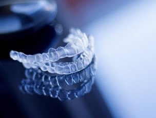 a pair of Invisalign aligners on a glass table