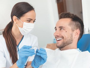 a dentist showing a patient the cost of Invisalign