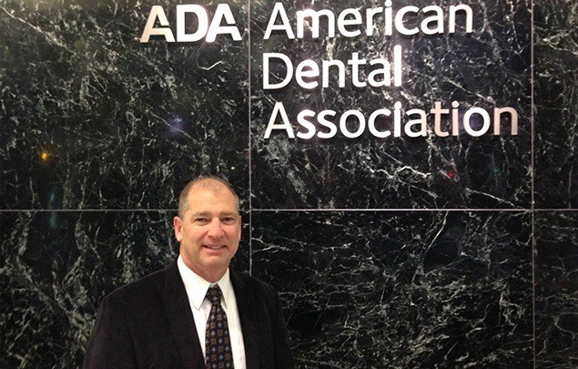 Doctor Kramer standing under American Dental Association sign