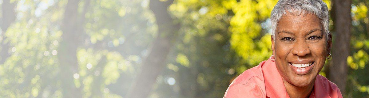 Older woman outdoors smiling after preventive dentistry in Selbyville