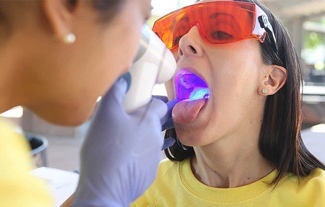 Woman receiving an oral cancer screening from her dentist