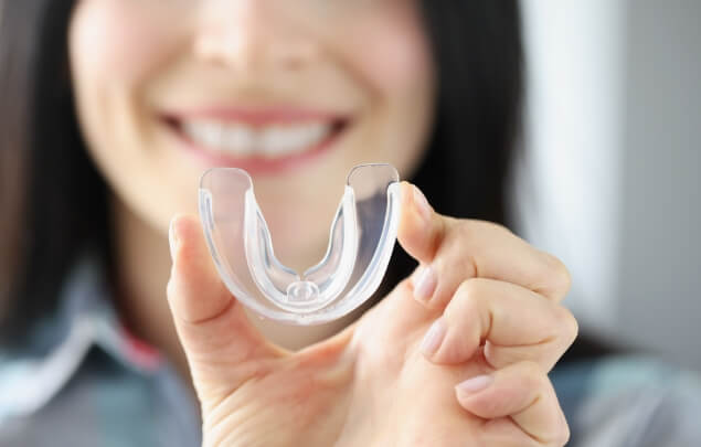 Close up of smiling woman holding a clear nightguard