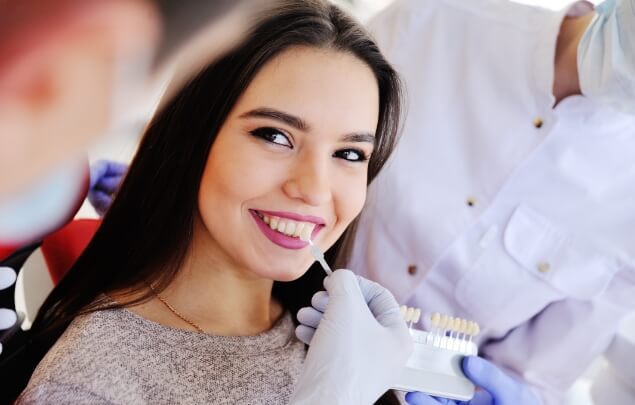 Young woman being fitted for veneers by her dentist