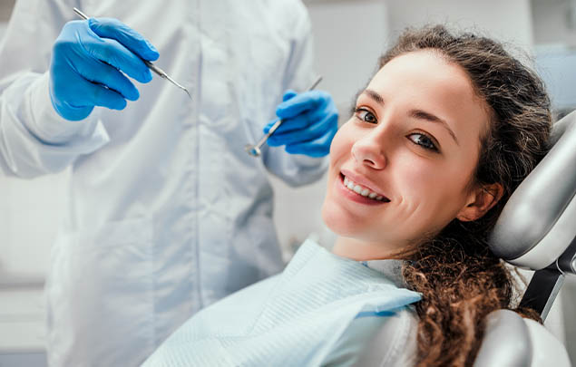 Smiling young woman leaning back in dental chair