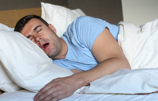 Man sleeping on his wide with his mouth open