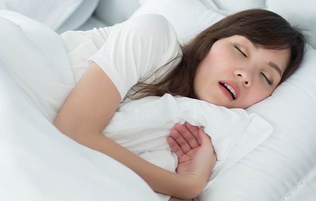 Woman sleeping on her side with her mouth open