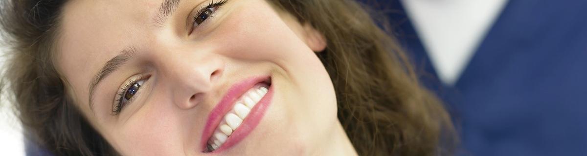 A woman with dark hair smiling after receiving veneers in Selbyville