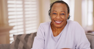 Woman smiles after making the transition from dentures to dental implants