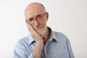 man experiencing pain from dentures