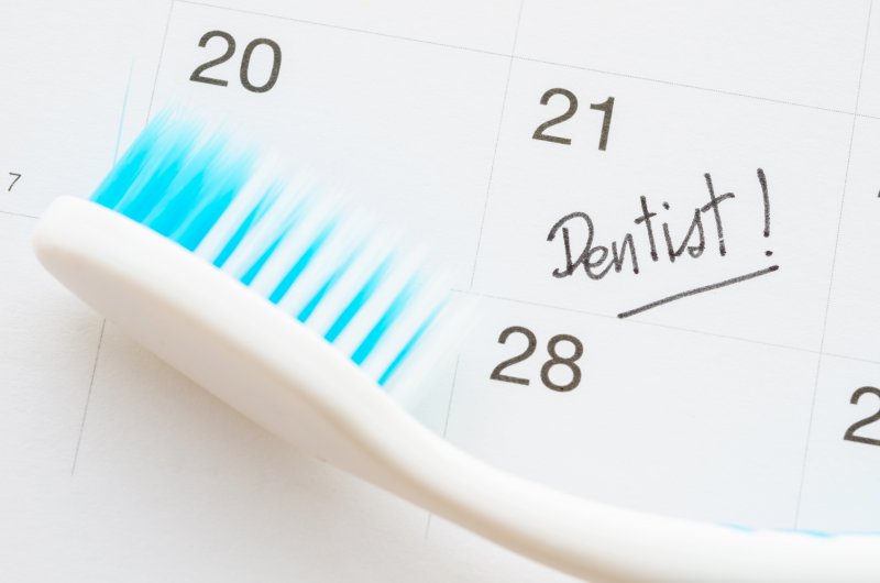 calendar with reminder to visit dentist and toothbrush