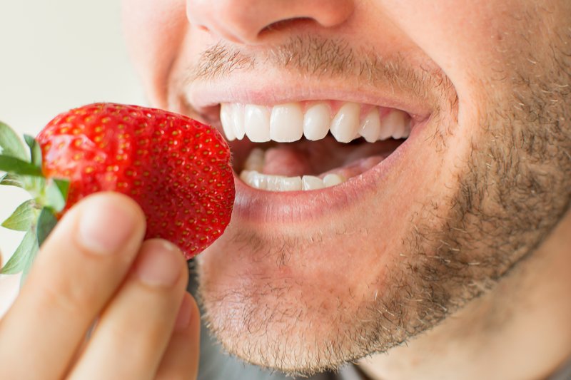 Close-up of man eating a strawberry