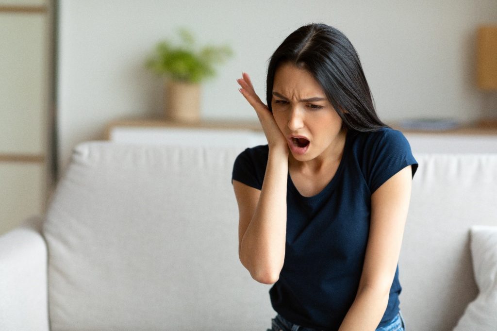 Woman experiencing pain from a toothache.