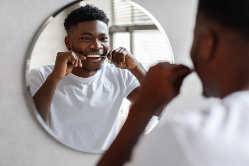 a man flossing with Invisalign in Selbyville