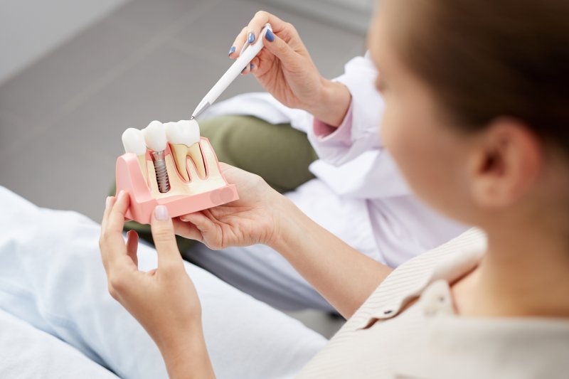 Dentist showing patient dental implant