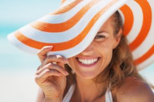 a woman smiling during summer with dental implants